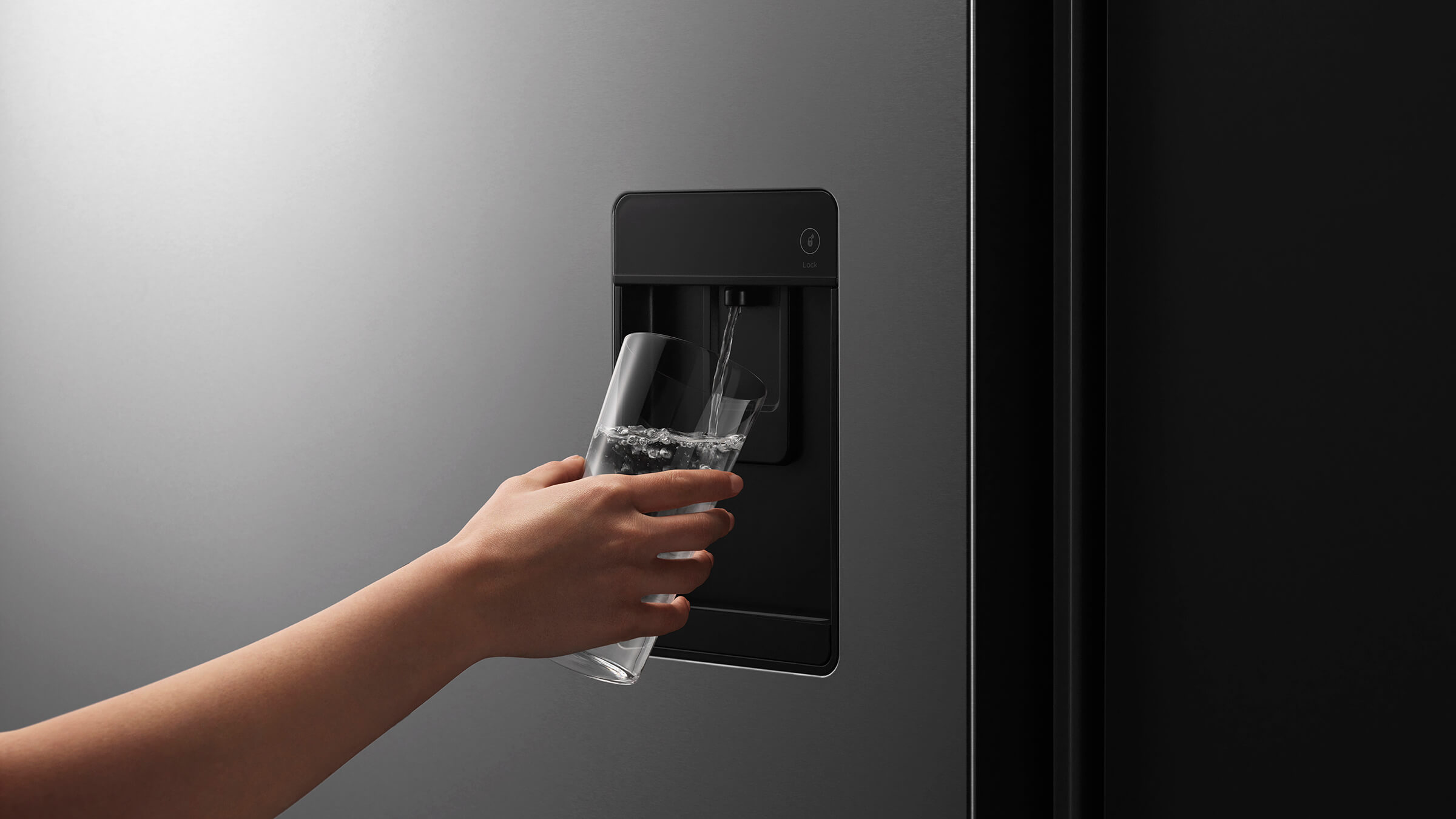 Close-up of a discreet external water dispenser on a stainless steel bottom freezer refrigerator